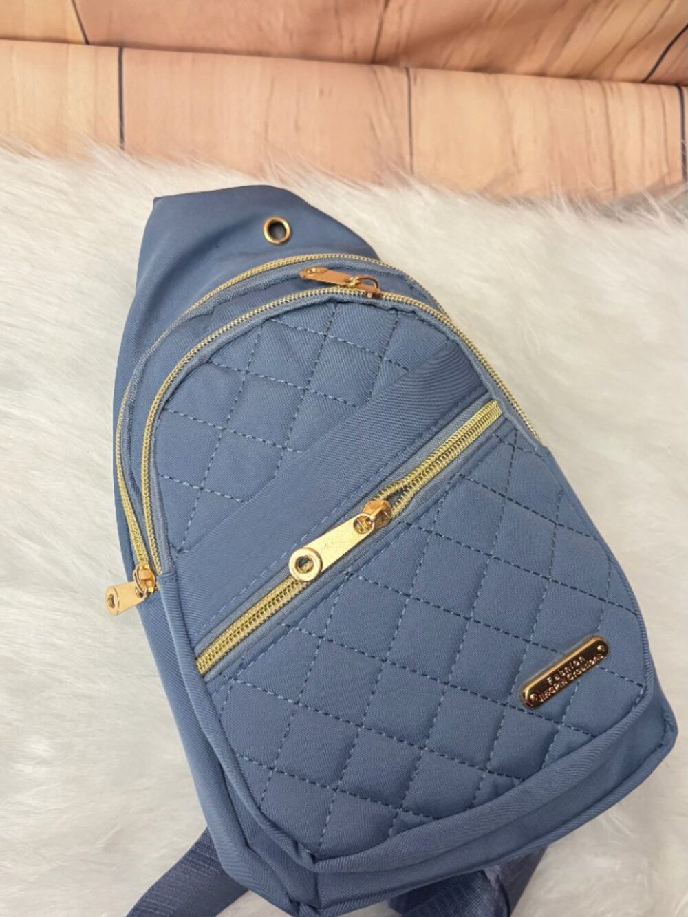 Blue quilted crossbody sling bag featuring a diamond-stitched front, gold-tone